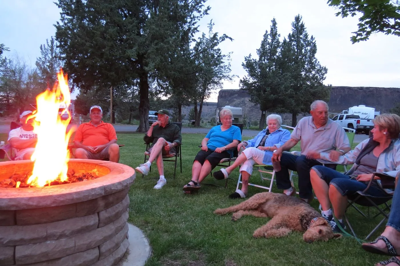 Guests gathered around a propane fire at camp